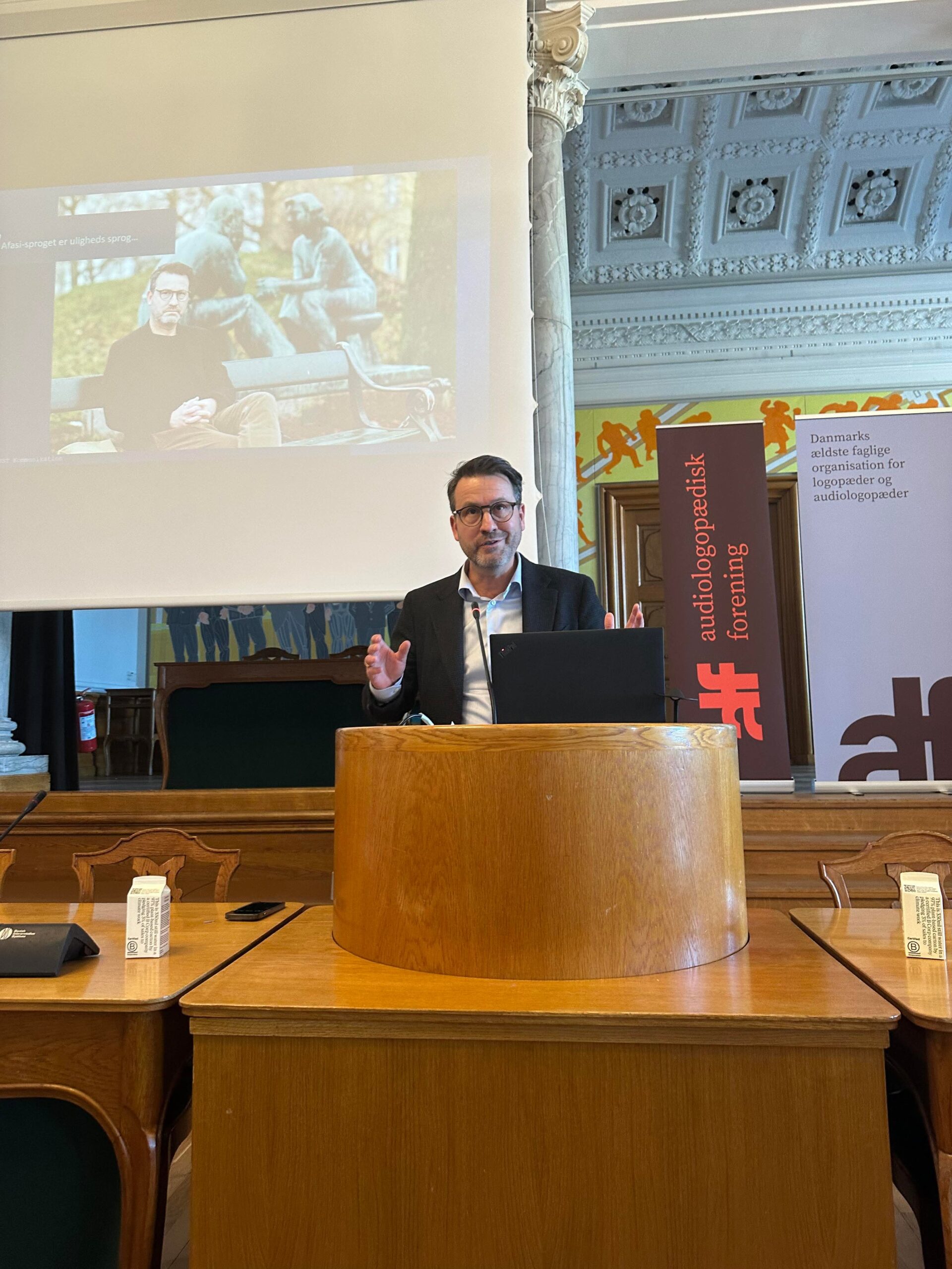 Image of Yago taking at a lectern during a lecture